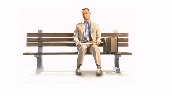 Forrest Gump ngồi trên băng ghế chờ xe buýt với hộp chocolate trên tay