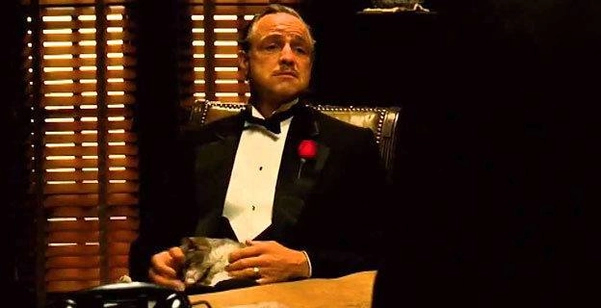 Hình ảnh ông trùm Vito Corleone trong văn phòng tối với con mèo trên tay